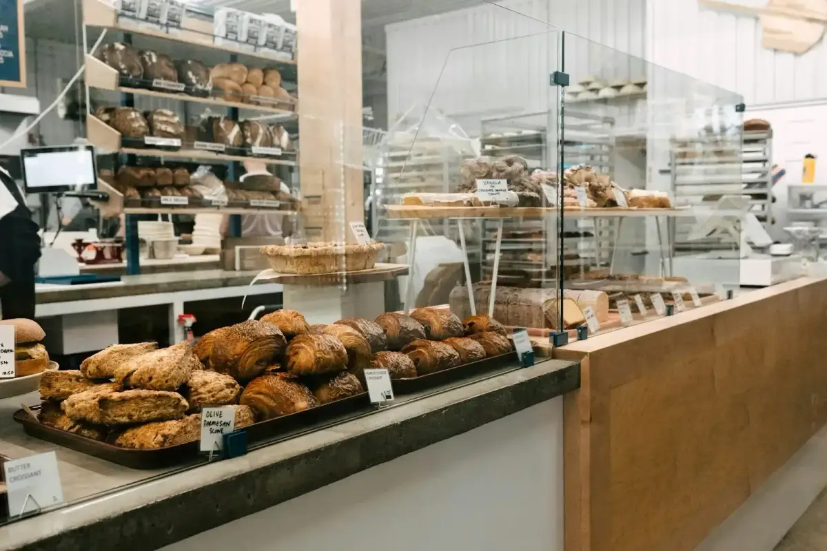 La boutique : un comptoir en bois et des étagères remplies de pains
