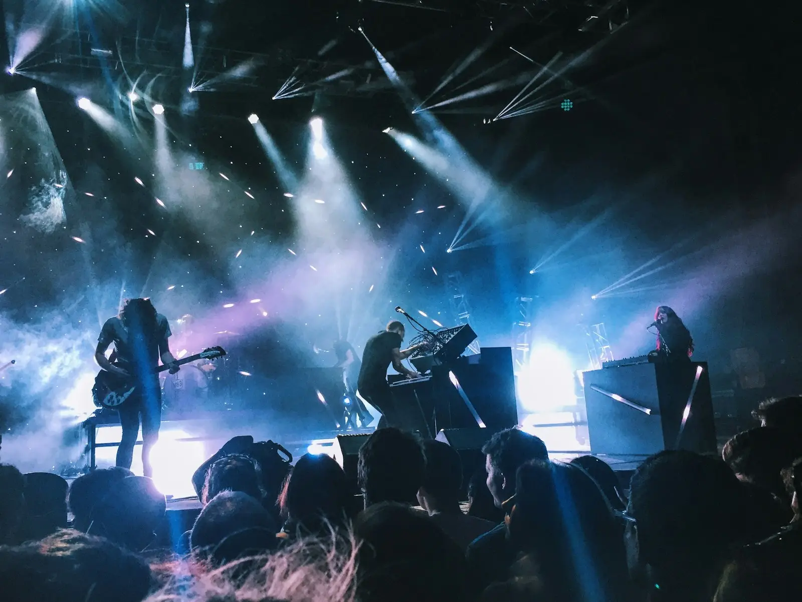 Le groupe sur scène sous des lumières bleues et violettes