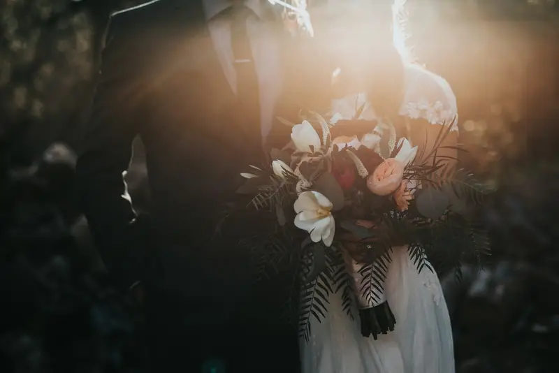 Mariée qui tient son bouquet dans une lumière chaude